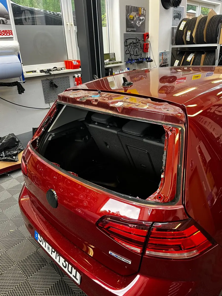 Roter VW Golf mit ausgebauter Heckscheibe in der Werkstatt