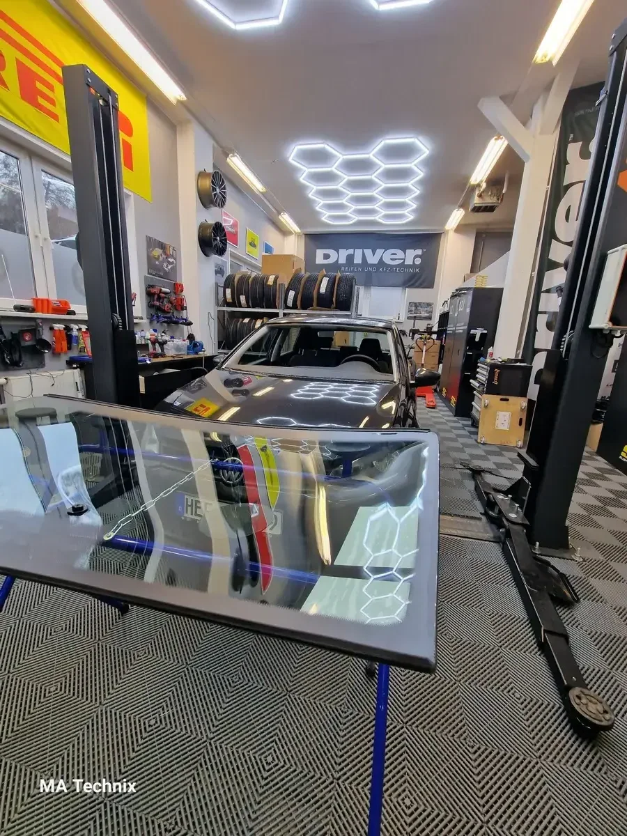 Werkstatt-Innenansicht mit Autoglas-Scheibe auf Gestell