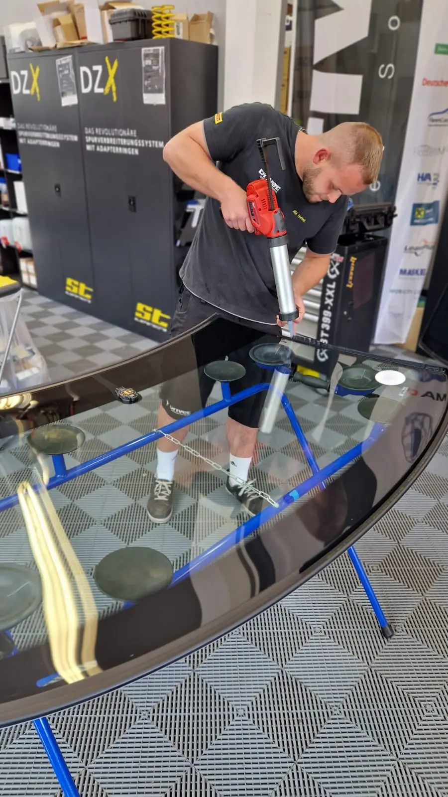 Mitarbeiter beim Einbau einer Windschutzscheibe - Detailansicht