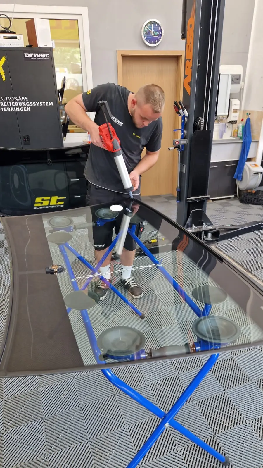 Mitarbeiter klebt Windschutzscheibe in der Werkstatt - Dein Autoglaser Schmalkalden